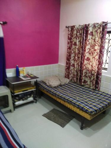 Zimmer mit einer Bank und einer rosa Wand in der Unterkunft Richmax pg in Jāmb