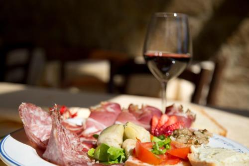 a plate of food and a glass of wine at Casale San Galgano in Chiusdino