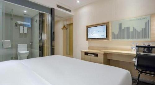 une chambre avec un lit et une télévision et une salle de bain dans l'établissement City Comfort Inn Dongguan Shijie Jiarong Shopping Plaza, à Dongguan