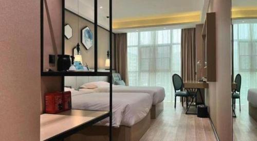 a hotel room with a bed and a desk with a mirror at Xana Lite Hotelle Yan'an Baota Mountain in Yan'an