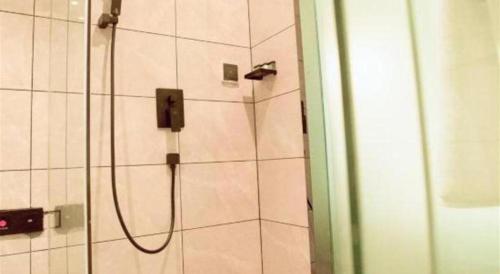 a shower with a shower head in a bathroom at Xana Lite Hotelle Yan'an Baota Mountain in Yan'an