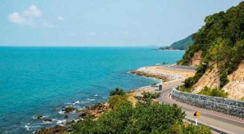 a road on a hill next to the ocean at AT Kung Kra baen Hotel and Residence in Chanthaburi