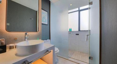 a bathroom with a white sink and a shower at Magnotel Hotel Xiamen North Station Binhai in Xiamen