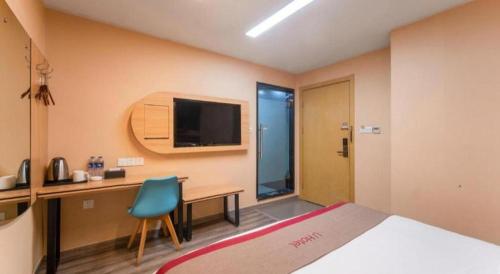 a room with a bed and a desk and a television at Thank Inn Hotel Jiangsu Wuxi High-Tech Zone Ruigang Pedestrian Street in Wuxi