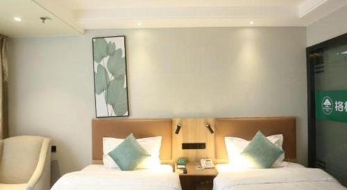 a hotel room with two beds and a chair at GreenTree Inn Anqing Yingbin Dong Road High-Speed Railway Station in Anqing