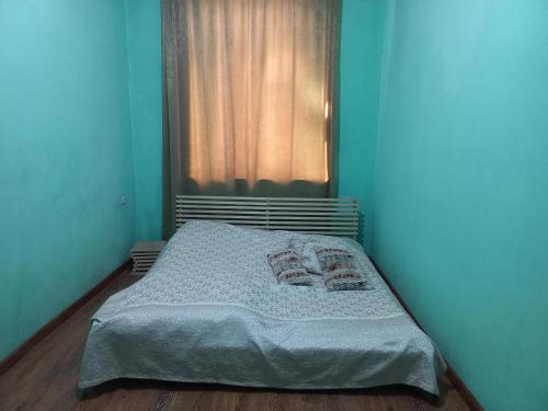 a bed in a blue room with a window at Comfortable Apartment in Aghk'ilisa