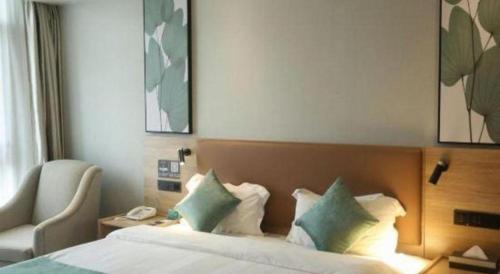 a hotel room with a bed and a chair at GreenTree Inn Anqing Yingbin Dong Road High-Speed Railway Station in Anqing