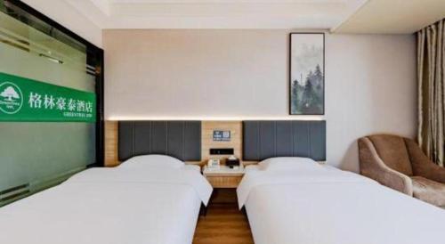 a hotel room with two beds and a couch at GreenTree Inn Anqing Yingbin Dong Road High-Speed Railway Station in Anqing