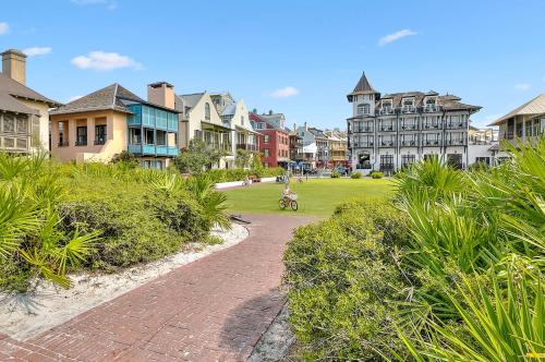 a brick walkway through a park with houses at Sand Pointe by 30A Escapes in Inlet Beach