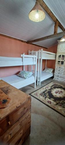 a room with two bunk beds and a table at Sitio Reis Membeca in Paraíba do Sul