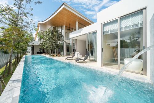 タラーンにあるThe Trinity new modern 5BR villa with 20M Poolの家の裏庭にあるプール