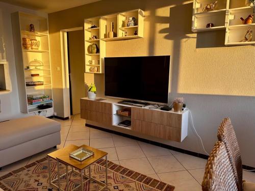 un salon avec une télévision à écran plat sur un mur dans l'établissement La Proue du Navire - Vue Mer, à Toulon