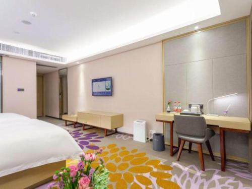 a bedroom with a bed and a desk and a computer at Lavande Hotel Huizhou Shiwan in Huizhou