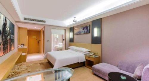 a hotel room with a bed and a couch at Vienna Hotel Guangdong Zhongshan Xiaolan High-Speed Railway Station in Zhongshan