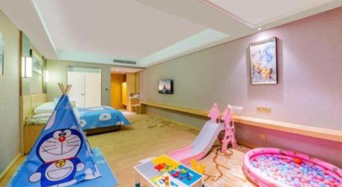 a childrens room with a play area and a bedroom at Vienna Hotel Guangdong Zhongshan Xiaolan High-Speed Railway Station in Zhongshan