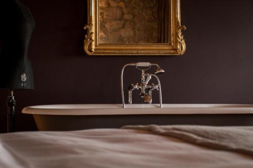 a bathroom with a sink and a mirror and a tub at Hotel Krone Regensberg in Regensberg