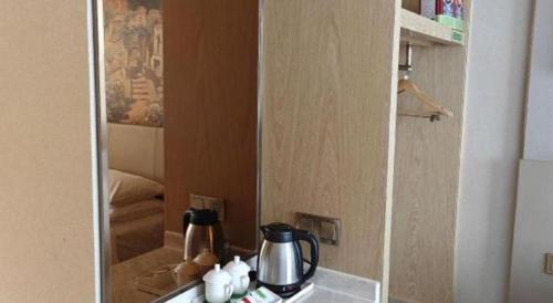 a cupboard with a kettle on top of a counter at Vienna Hotel Guangxi Wuzhou High-Tech in Wuzhou