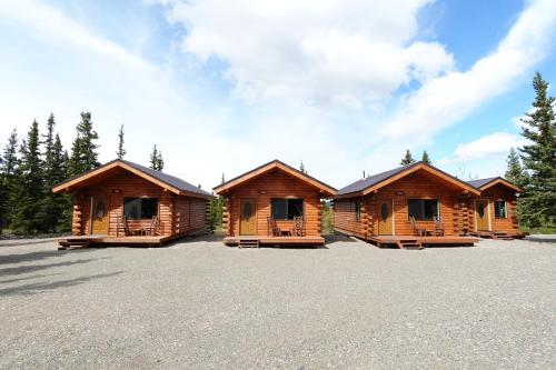 a row of wooden cabins in a parking lot at Moose-AKa's Cabins in Healy