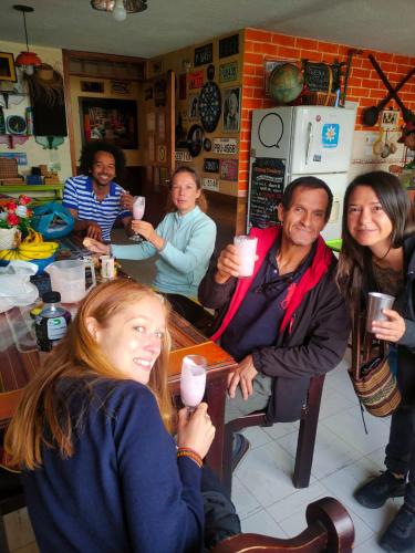 a group of people sitting around a table with drinks at Flying Donkey in Otavalo
