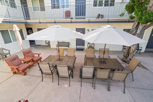 an outdoor patio with tables and chairs and umbrellas at Gorgeous Beach Condo with Private Patio #134 in Carpinteria