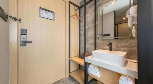 a bathroom with a sink and a mirror at GreenTree Inn Express Qingdao Jiaodong International Airport in Qingdao