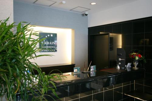 a lobby with a reception desk and plants at Urbain Hiroshima Executive in Hiroshima