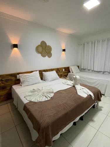 a bedroom with two beds with white sheets at Pousada Villa Mar Porto in Porto De Galinhas