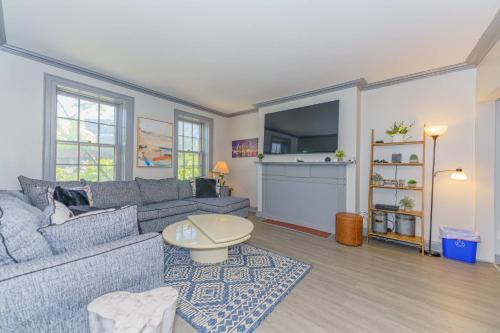 a living room with a couch and a tv at Massive 5BD/4BA 3-Story Duplex @ Downtown Albany in Albany