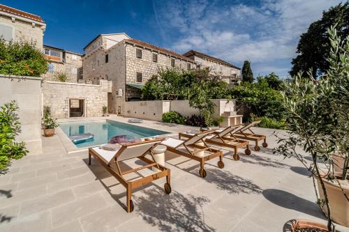 a group of chairs sitting next to a swimming pool at Villa Kaleta Brac in Sutivan