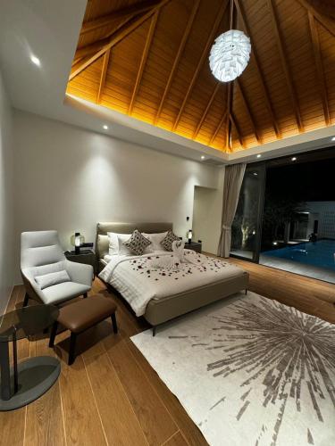 a bedroom with a bed and a couch and a chair at The Nature Villa Phuket in Rawai Beach