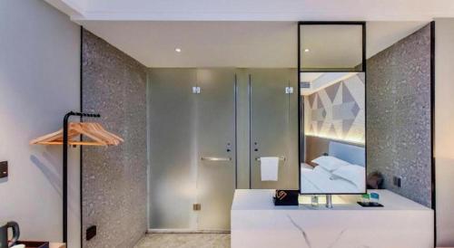 a bathroom with a large mirror and a sink at Borrman Hotel Chongqing Bishan Central Street in Chongqing