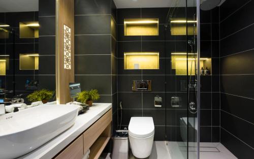 a bathroom with a sink and a toilet and a shower at Queenco Hotel & Casino in Sihanoukville