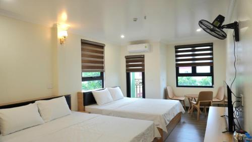 a hotel room with two beds and a television at Jademay Airport Hotel in Sóc Sơn