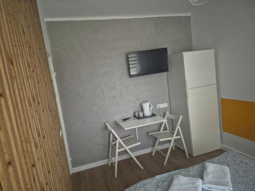 a small room with a table and a refrigerator at Pokoje Bema 14 in Ciechocinek