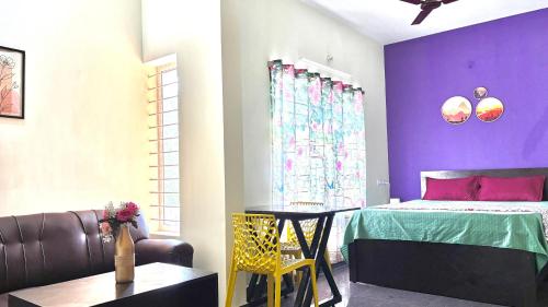 a room with a bed and a table and a couch at Samuels Comfort Homes in Bengaluru