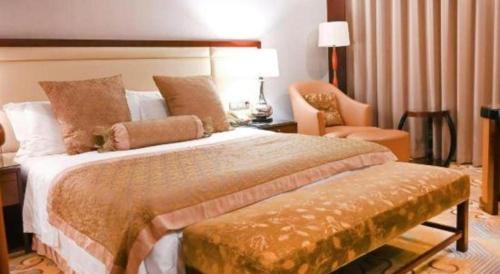 a bedroom with a large bed and a chair at Royal Tulip Hotel Zhujiajiao Shanghai in Shanghai