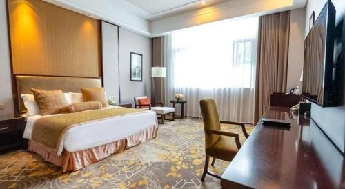 a hotel room with a bed and a television at Royal Tulip Hotel Zhujiajiao Shanghai in Shanghai