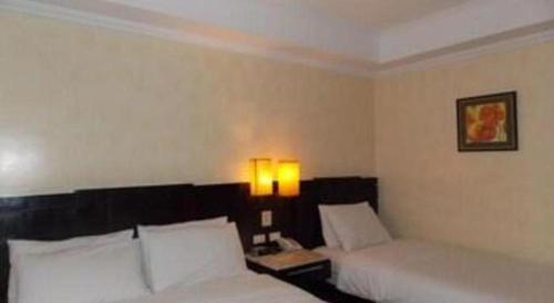 a hotel room with two beds and two lamps at MO2 Westown Hotel San Juan in Bacolod