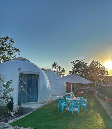 a round house with a table and chairs in a yard at Iglú Sparrow vista al cielo in Barra de Navidad