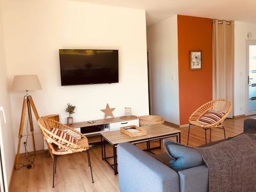 a living room with a couch and a table at Maison cosy à 300m de la plage avec spa in Plouescat