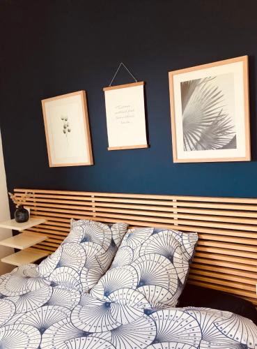 une chambre avec un lit avec trois tableaux au mur dans l'établissement Maison cosy à 300m de la plage avec spa, à Plouescat