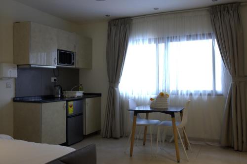 a room with a kitchen and a table with chairs and a kitchen at CasaNova Airport Suites in Accra