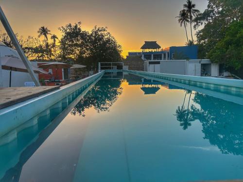 a swimming pool with a sunset in the background at Iglú Sparrow vista al cielo in Barra de Navidad