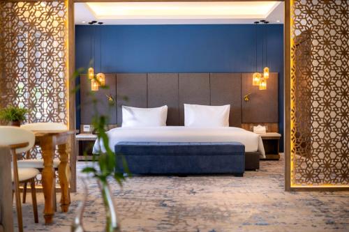 a bedroom with a large bed and a blue wall at Queenco Hotel & Casino in Sihanoukville