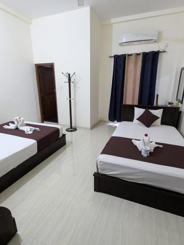A bed or beds in a room at Trinco Star Hotel