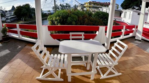 a white table and two chairs on a balcony at Pension Ciel d'Eté in Port Mathurin