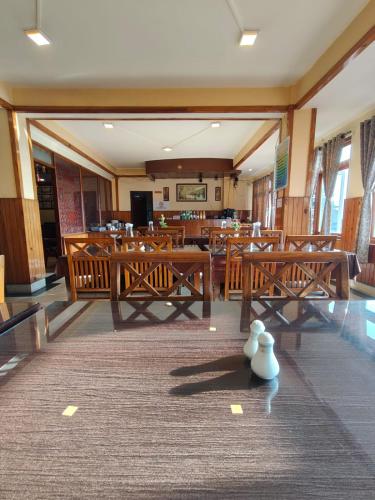 a dining room with wooden tables and chairs at Hotel Utpala in Gangtok