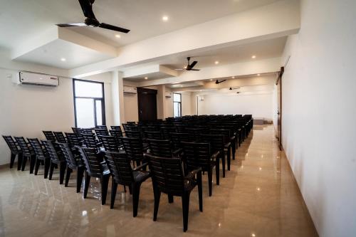 an empty room with black chairs in a room at Cross Roads Inn in Coimbatore