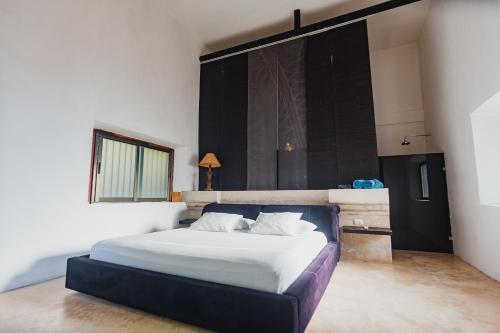 a bedroom with a large bed in a room at Hacienda Sacnicte in Izamal