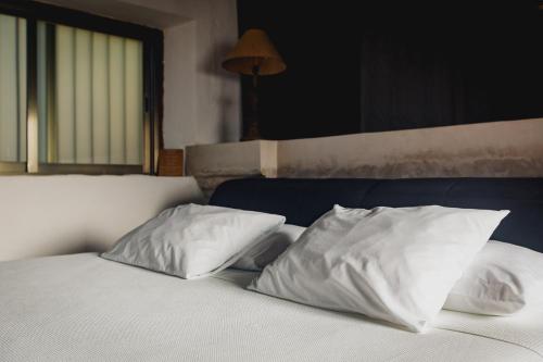 a bed with two white pillows on top of it at Hacienda Sacnicte in Izamal